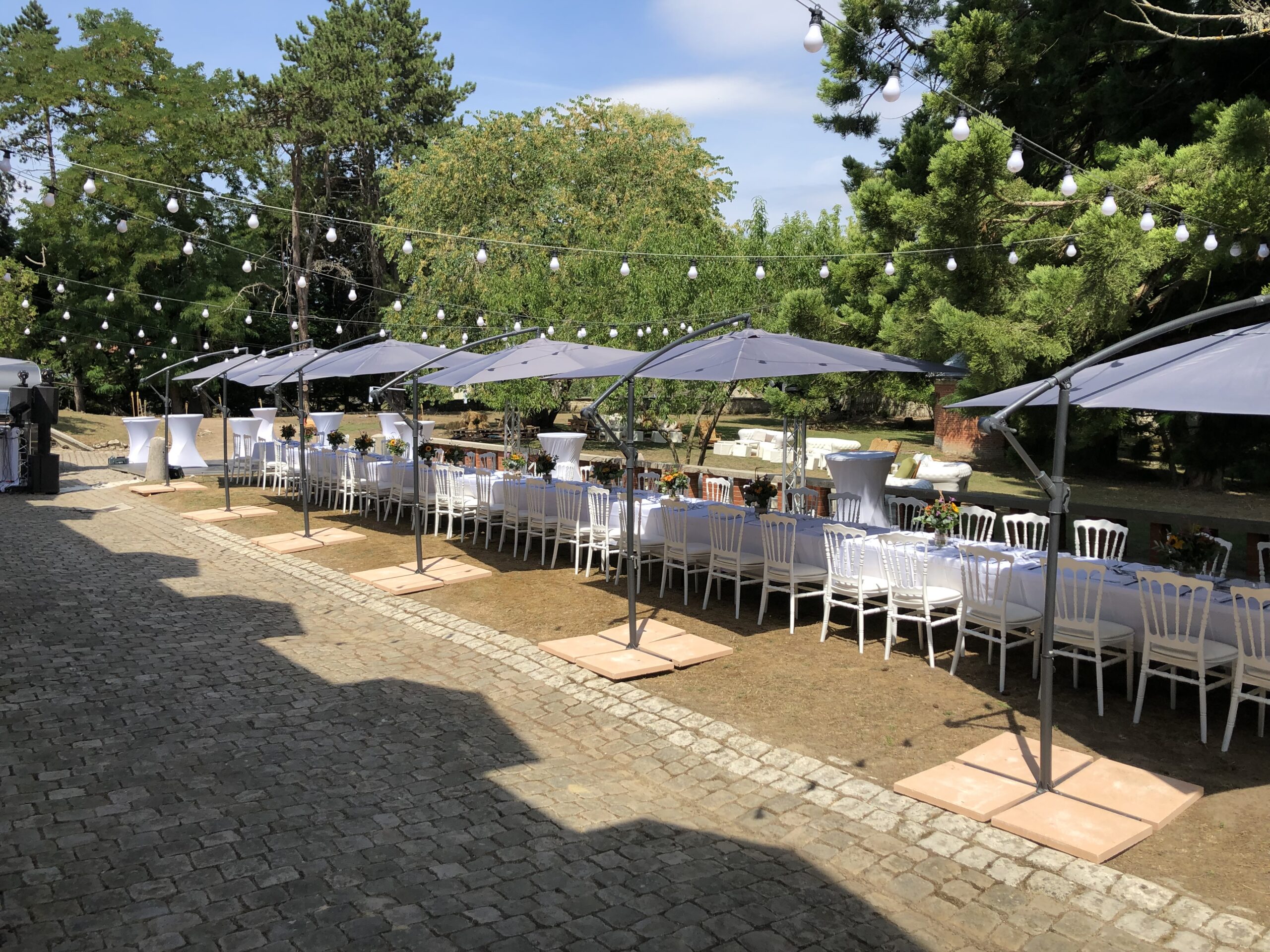 http://Location%20de%20mobilier%20Jani%20Event.%20Table%20rectangle,%20guirlande%20guinguette,%20parasol%20déporté%20et%20chaise%20napoléon.